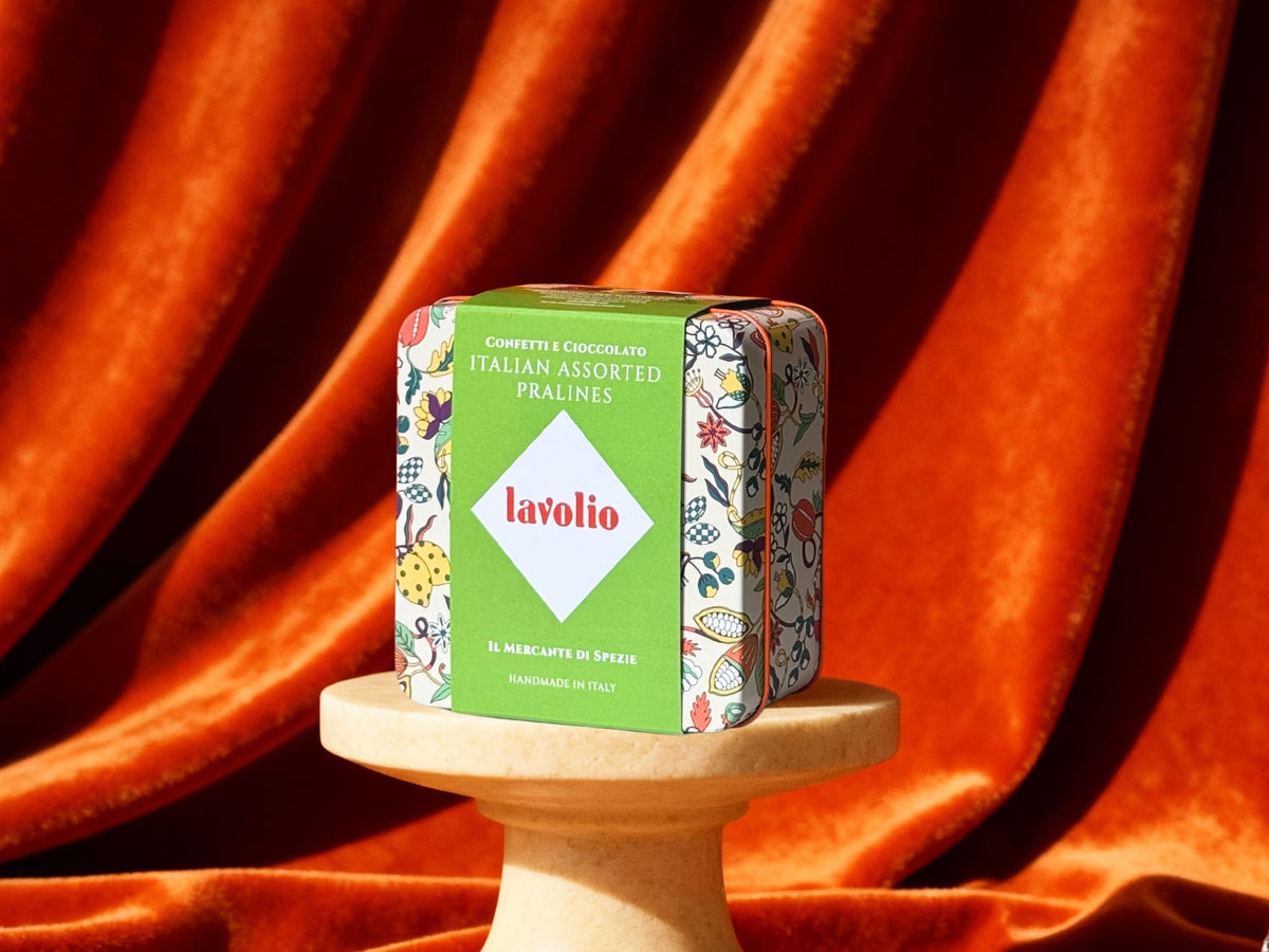 Lavolio box pralines tin on a stand with an orange curtain background